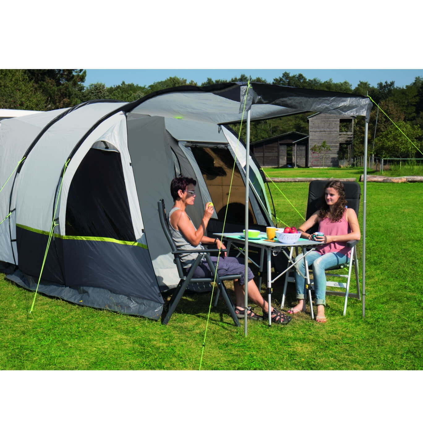 Tour compact drive away awning with people sitting outside and enjoying the sun