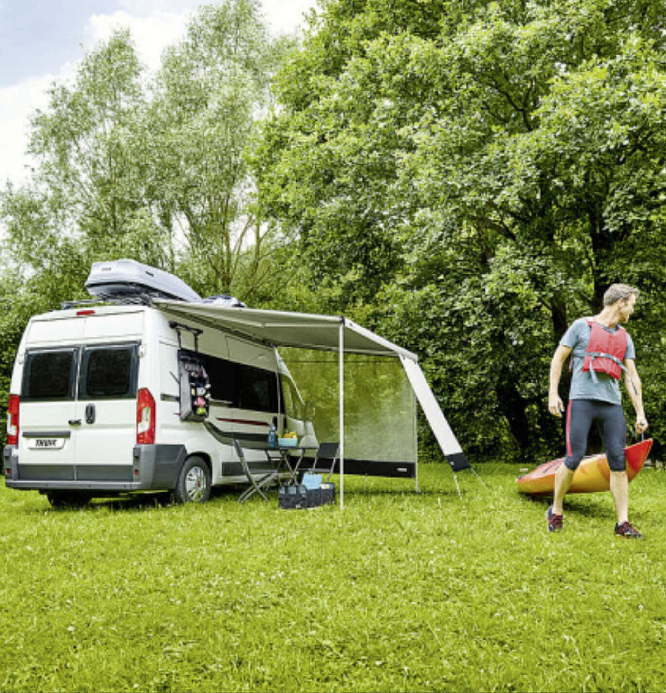 The thule 6300 awning pitched and man walking away with a rowing boat