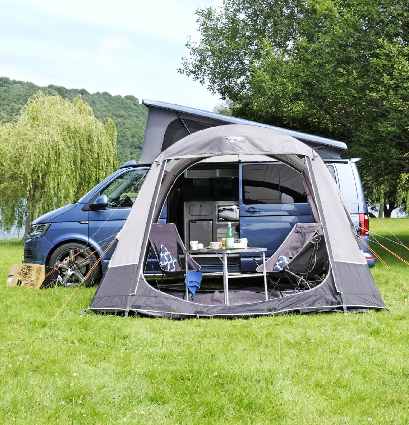 Vango Kela pitched, open and set up with camping furniture